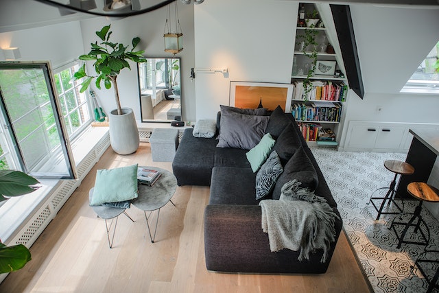 arial shot of a living room with light wood floors and a dark grey couch